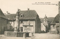 Vieille Fontaine surmontée du Coq Gaulois et l'Eglise